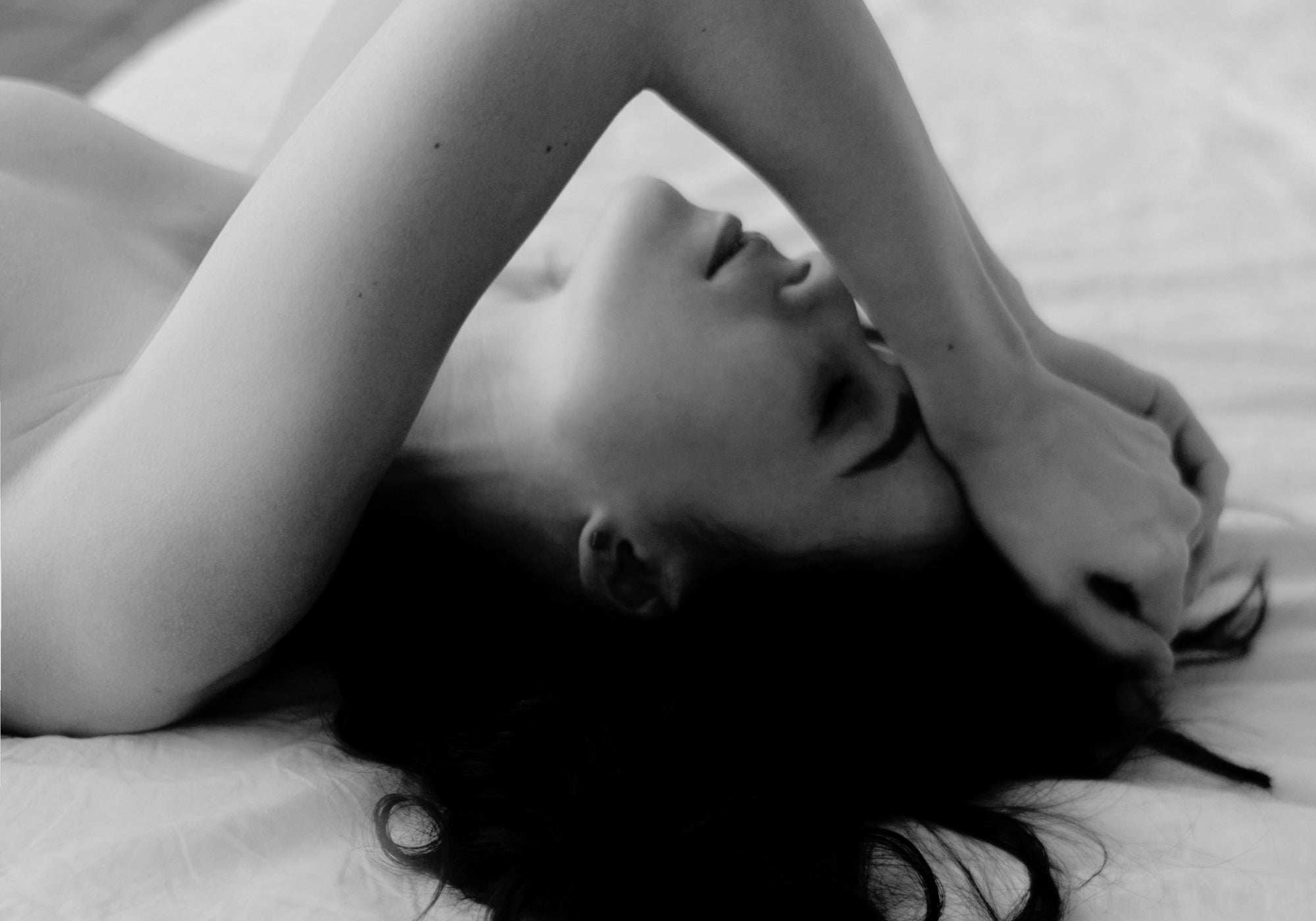 woman lying on bed, hands on hair