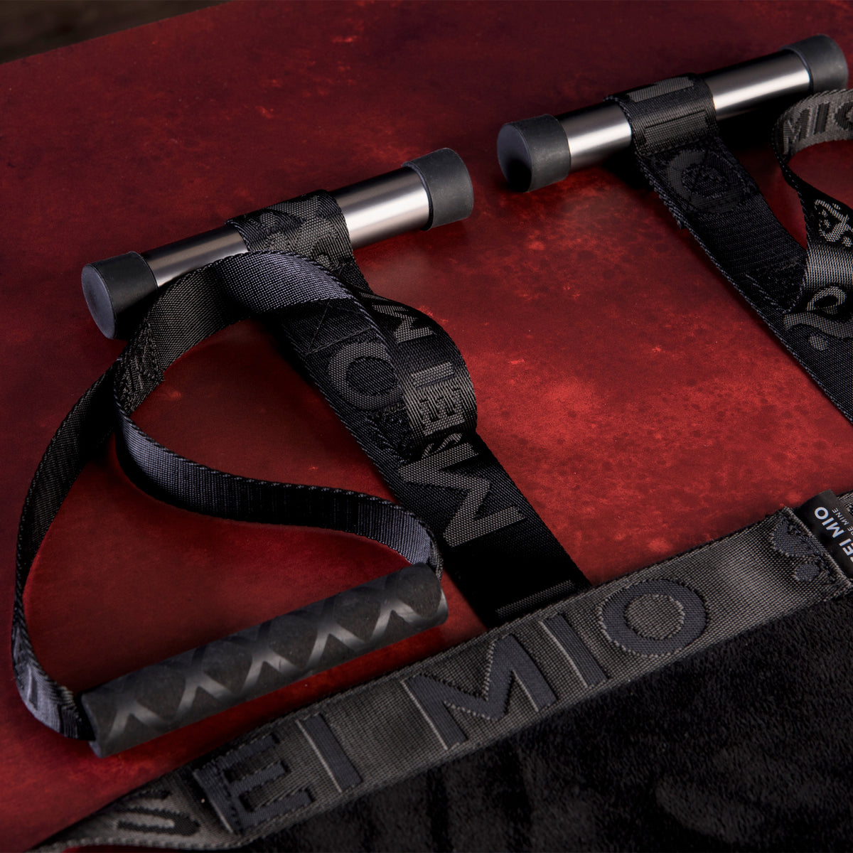 Close-up of the Sei Mio door swing's non-slip door bars and comfort grip handles on a red background