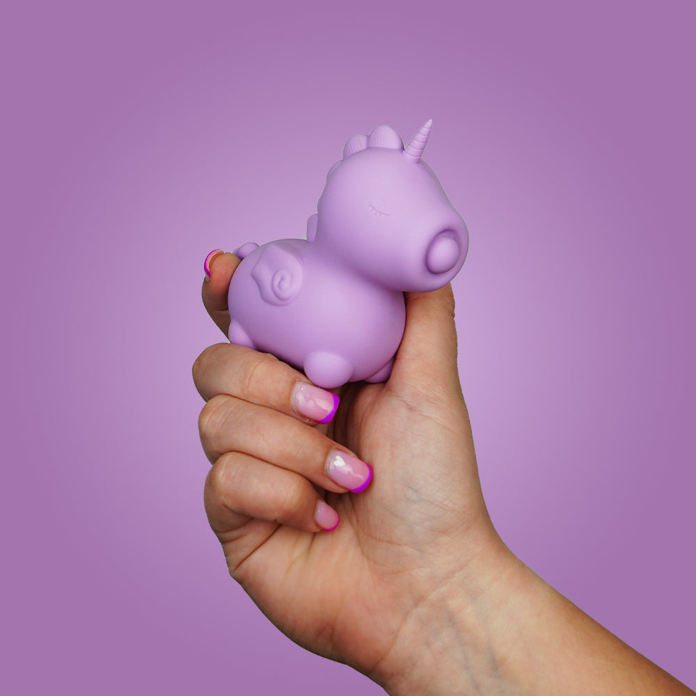 Hand holding the lilac Unihorn Karma Lilac clitoral vibrator