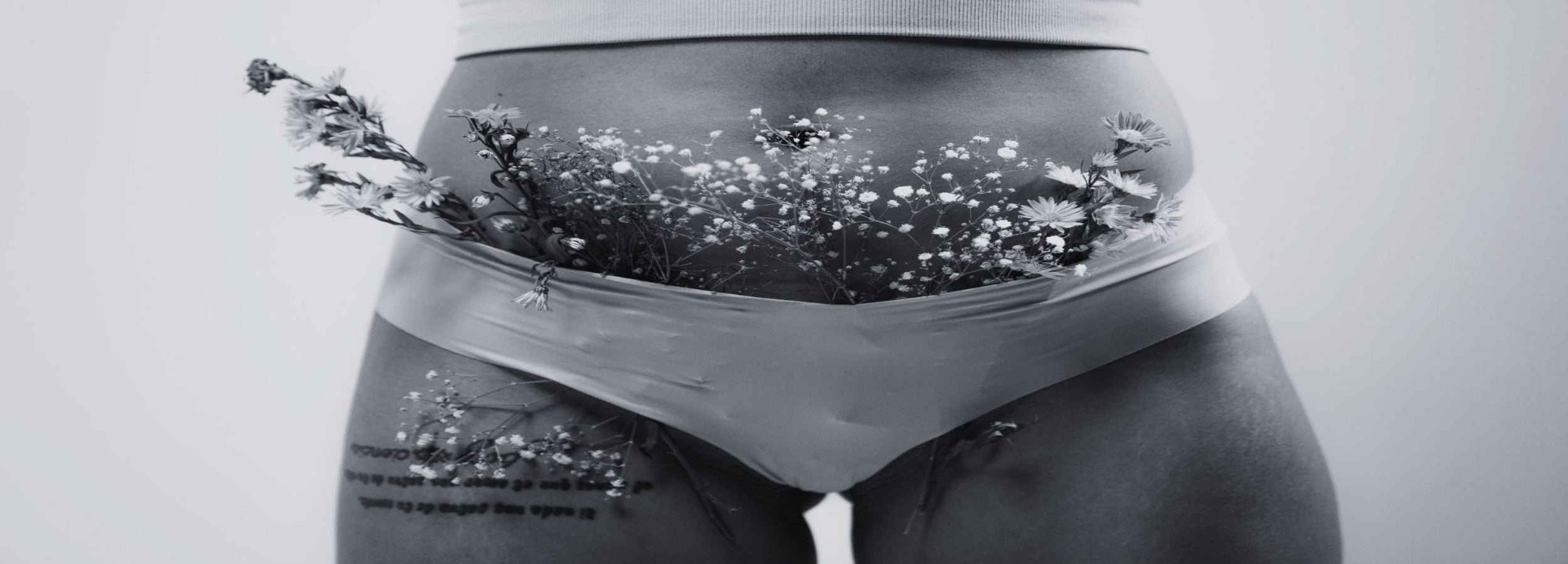 Person wearing underwear with floral design and text overlay on a light gray background