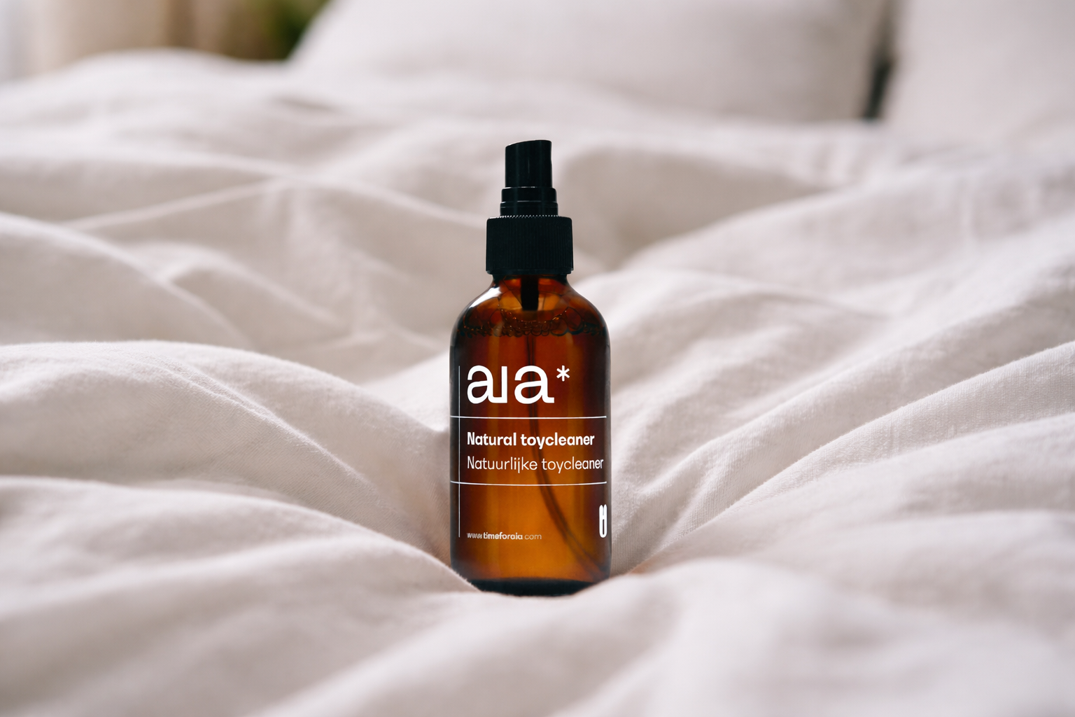 Brown bottle of aia natural toy cleaner on white fabric