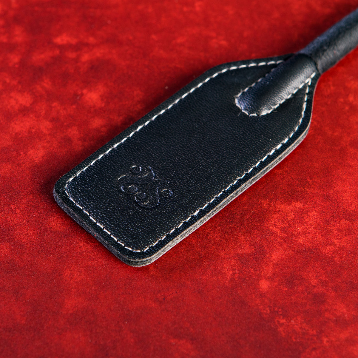 Close-up of the stitched faux leather slapper with embossed Sei Mio logo