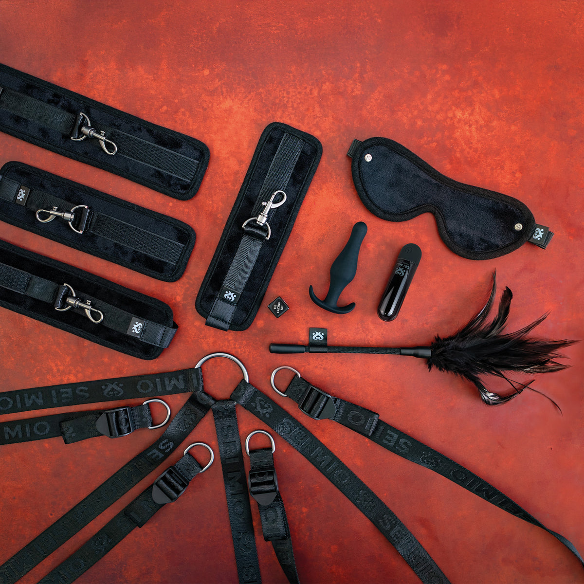 Sei Mio Complete Surrender set on red: under-bed straps, padded cuffs, blindfold, plug, bullet vibrator, tickler and dice