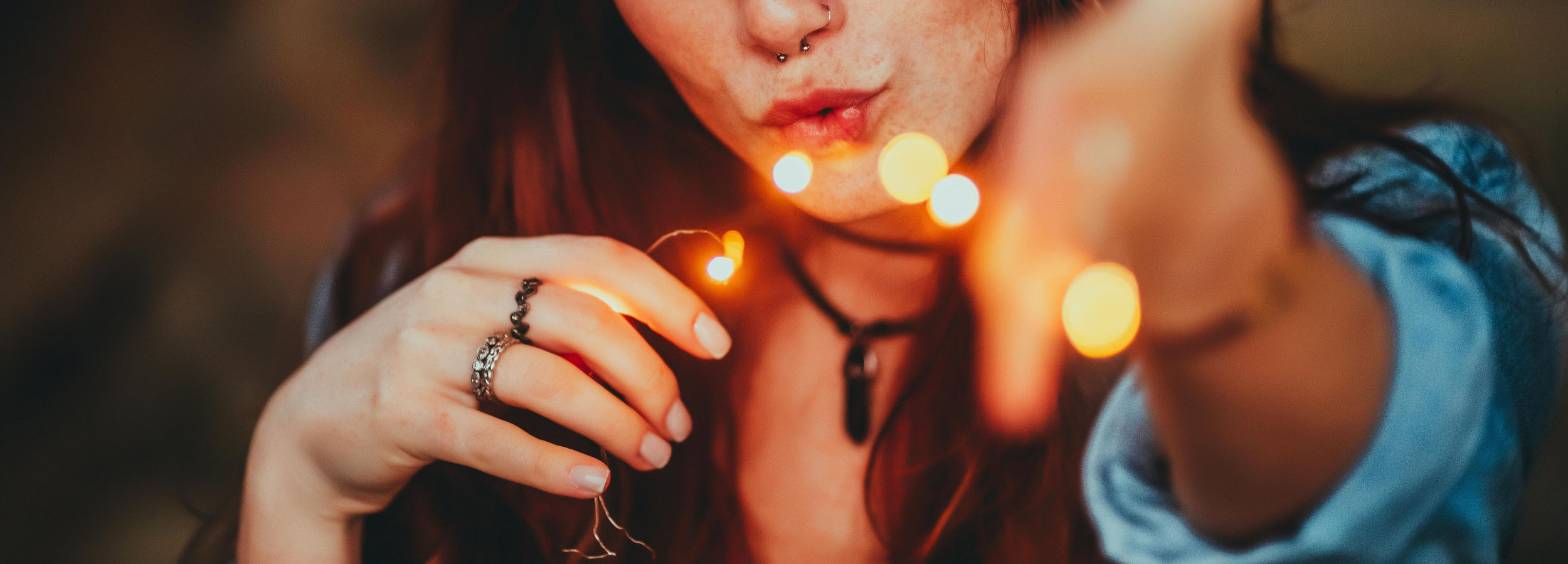 Person holding two lit candles with a blurred background