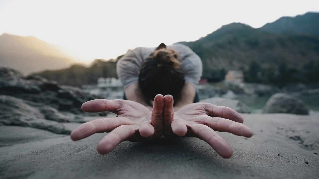 a woman stands up on a beach in the morning. She's relaxed and happy.