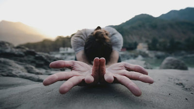 a woman stands up on a beach in the morning. She's relaxed and happy.