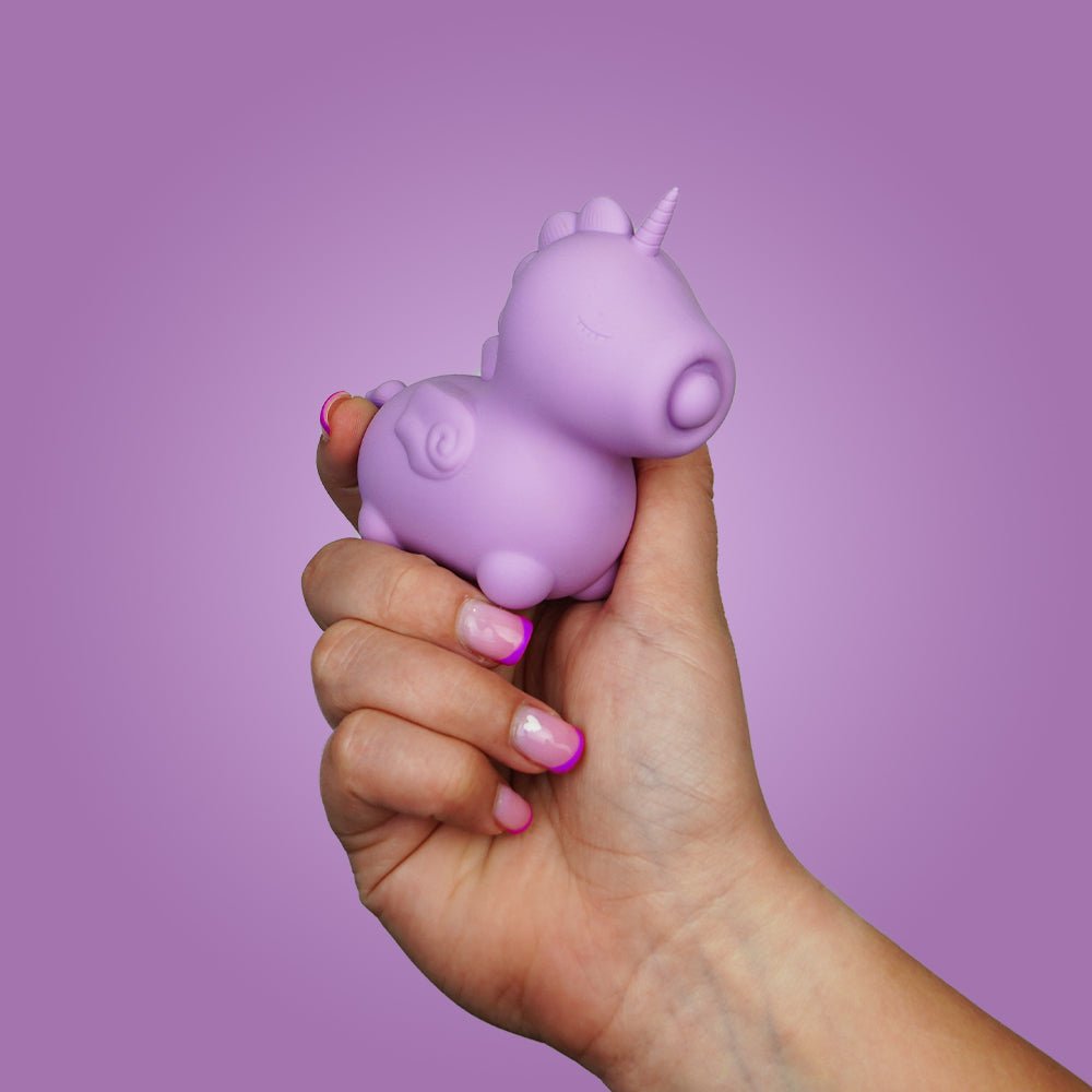 Hand holding the lilac Unihorn Karma Lilac clitoral vibrator