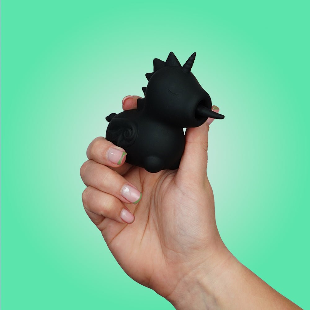 Hand holding the black Unihorn Wild Spirit clitoral vibrator